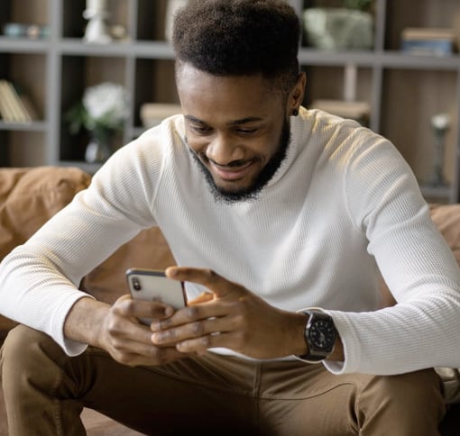 smiling man texting on a phone