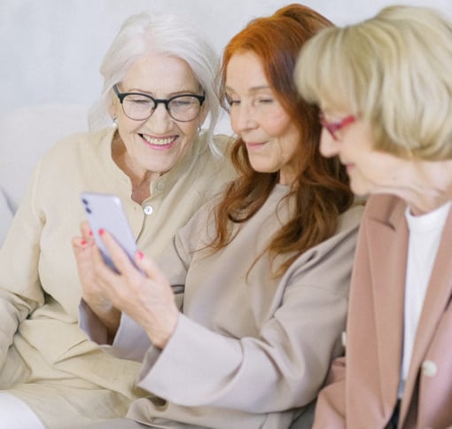 three older woman video chatting from one phone